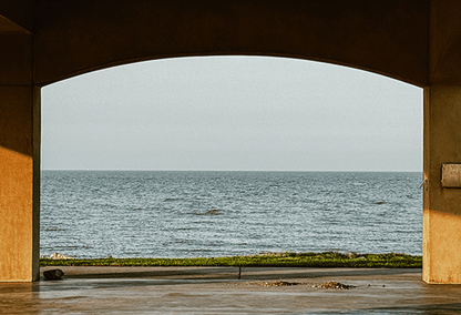 Serene ocean view framed by a concrete structure at the shore.