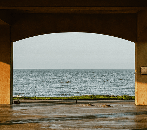 Serene ocean view framed by a concrete structure at the shore.